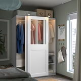 Modern white PAX wardrobe with glass doors, clothes, sliding doors, adjustable shelves.
