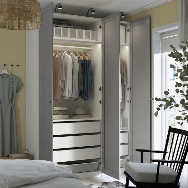Open gray wardrobe displaying clothes, drawers, and organized storage compartments, with integrated lighting.