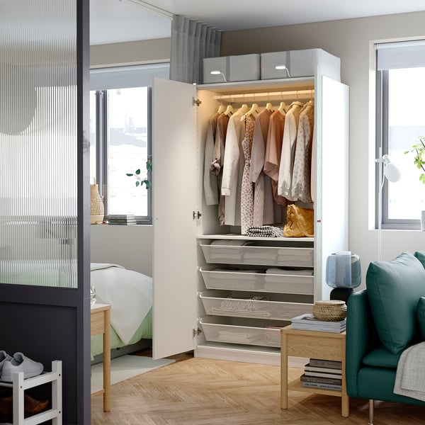 Wardrobe with organized clothes & drawers, integrated lighting.