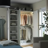 Organized closet with shelves and hangers. Clothes are neatly arranged, showcasing a functional storage solution.