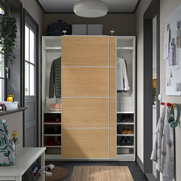 Modern closet with sliding doors in an entryway, featuring shoe shelves, coat hangers, and organizing boxes.
