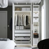 Open wardrobe displaying clothes, accessories, and storage boxes. Includes shelves, drawers, and a hanging rod.