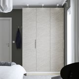Large light PAX wardrobe in modern bedroom, flanked by white door and black chair.