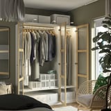 Modern open wardrobe with clothes, sheer doors, light, and storage boxes.