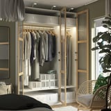 Open wardrobe with clothes, folded items, clear boxes, and interior lighting.