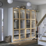 Large PAX wardrobe with glass doors in living space near stairs.