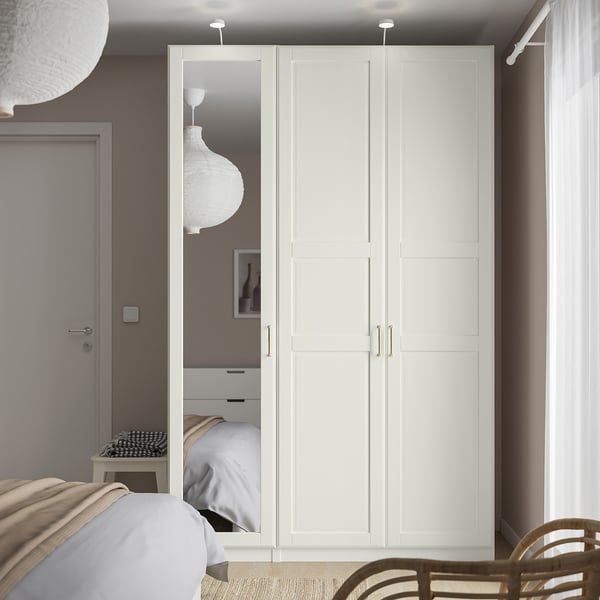 Modern bedroom with tall white PAX wardrobe and neutral tones.