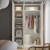 Open closet with clothes, baskets, and folded items, organized neatly.