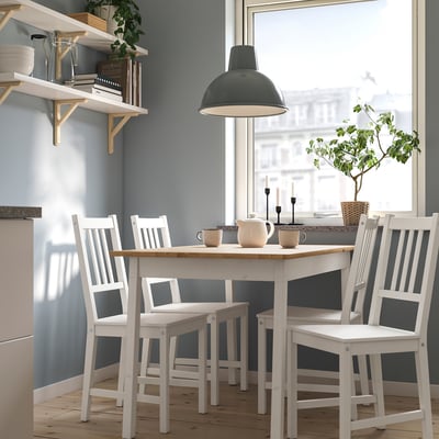 Small white PINNTORP table and chairs set with pendant light, plant, and candle holders.
