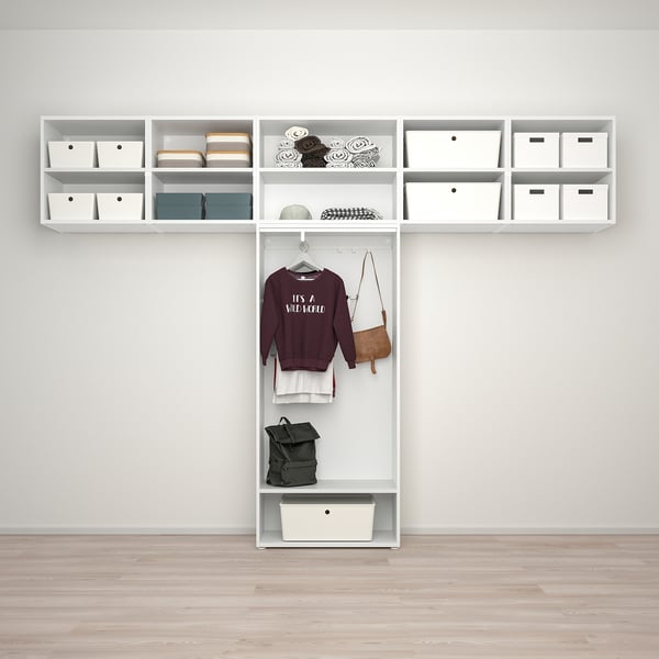 Organized closet with shelves holding white boxes and accessories, featuring a hanging area with a maroon sweatshirt, handbag, and green backpack.