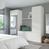 Minimalist bedroom with PLATSA storage, bed, rug, and towels.