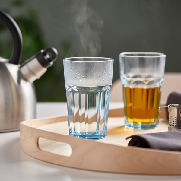 Tray with two glasses: one steaming, one filled with tea, next to kettle.