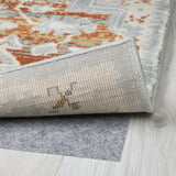 Multicolored rug with rolled edge on wooden floor.