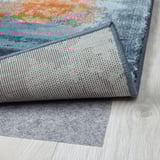 Rug close-up. Soft, textured surface, tightly woven edges. Light wood floor shown.