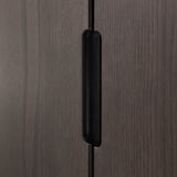 Dark wood cabinet close-up. Vertical grain detail visible. Long black handle attached, showcasing craftsmanship and quality.