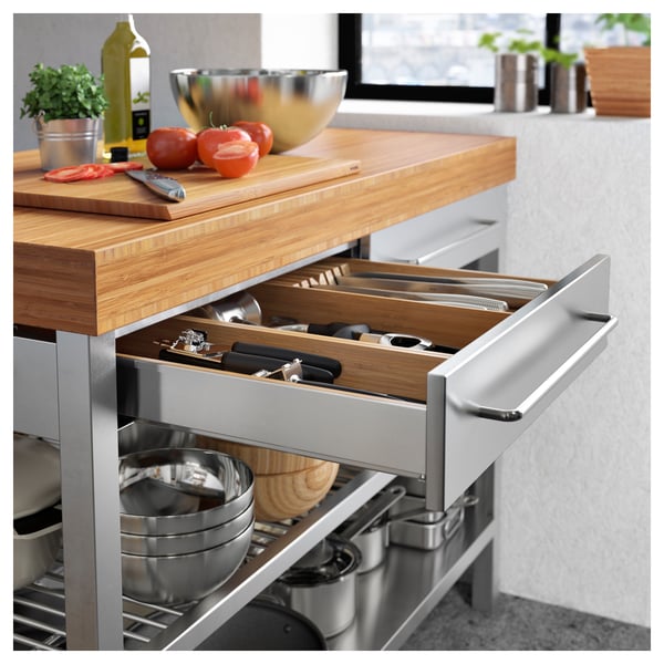 Kitchen island with bamboo top, stainless steel base, and wooden drawer organizer.