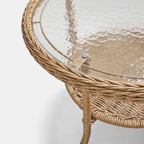 Wicker side table with clear, patterned glass top, showcasing quality craftsmanship and stylish design.