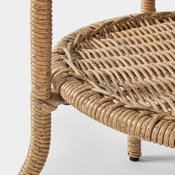 Close-up of intricately woven wicker side table, showcasing high-quality craftsmanship and natural texture.