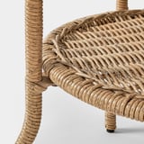 Close-up of intricately woven wicker side table, showcasing high-quality craftsmanship and natural texture.