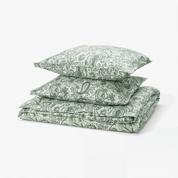 A stack of green paisley bed linens, neatly folded, featuring intricate swirls and leaves on soft cotton-viscose fabric.
