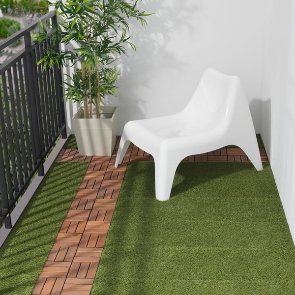 Modern balcony with white RUNNEN chair and bamboo plant.