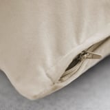 Close-up of a plush, beige cotton velvet cushion cover with a quality zipper, showcasing its soft texture and smooth finish.