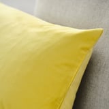 Bright yellow cushion cover, smooth velvet texture, soft and inviting.