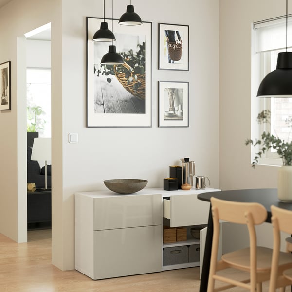 Modern living room: glossy cabinet, art, wooden chairs, kettle.