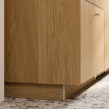 Light brown wooden kitchen cabinet plinth.