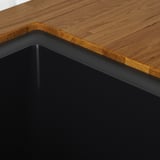 Wooden table edge, smooth, durable surface. Black metal frame support.