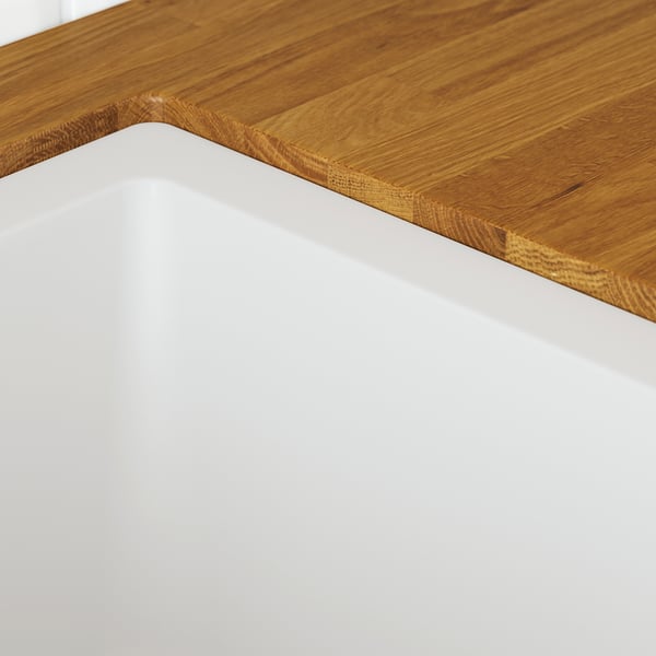 Wooden countertop corner, smooth finish, natural grain visible.
