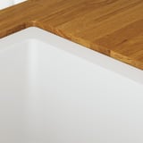 Wooden countertop corner, smooth finish, natural grain visible.