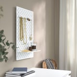 Wall-mounted SKÅDIS organizer with hooks and shelf holding necklaces, pendants, and a jar.