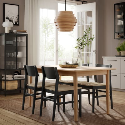 Modern dining area with SKANSNÄS table and chairs, light wood and black, minimalist design, natural light.