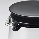 Close-up of robust glass pitcher with strainer lid, showing high-quality materials and design.