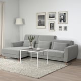 Minimalist living room with gray sofa, coffee table, and gallery wall.