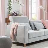 Cozy living room with grey SLATORP sofa, light pink curtains, and plants. Soft cushions and a blanket add comfort.