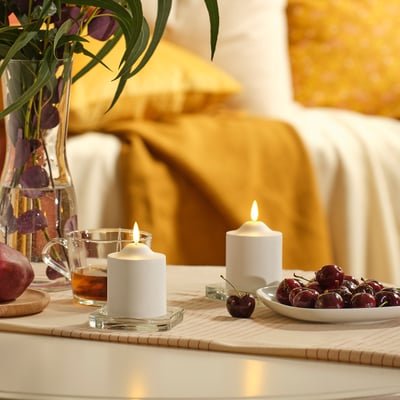 A white cylindrical SMÅLOM led candle with a rounded top and a small finial. Made of polypropylene plastic, its designed to mimic real candles safely.