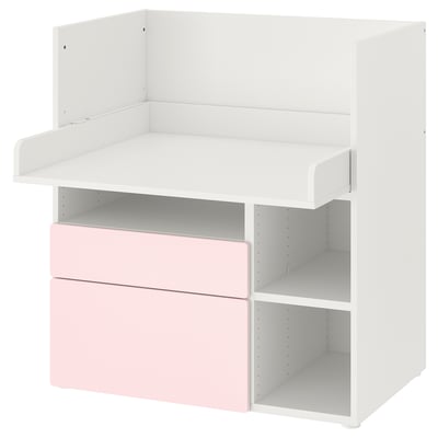 Depicts a white and light pink kids desk with storage. It an open shelf design, suitable for play and study.