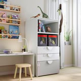 Childrens playroom with white SMÅSTAD bookcase and storage, wooden stool, desk, lamp, shelves with books, toys, and art supplies.