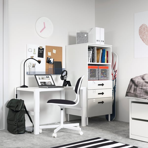 White SMÅSTAD bookcase with drawers in childs room, desk, laptop, headphones, backpack, bulletin board.