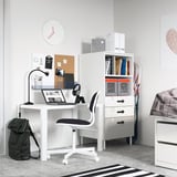 White SMÅSTAD bookcase with drawers in childs room, desk, laptop, headphones, backpack, bulletin board.