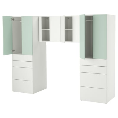 Modern white kids storage unit with multiple drawers and cabinets in various sizes, including a wardrobe. Light green accents add a playful touch.