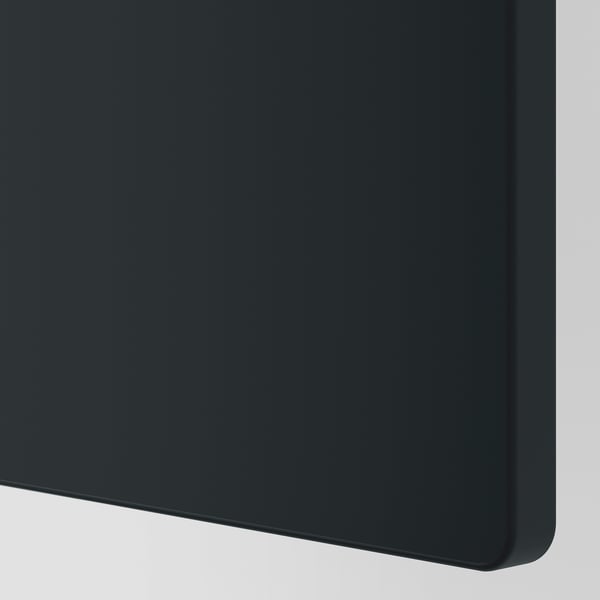 Black storage unit corner in closeup; smooth edges, glossy surface.