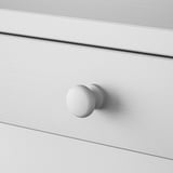 Round, white knobs on sleek, smooth drawer; minimalist design, sturdy construction.