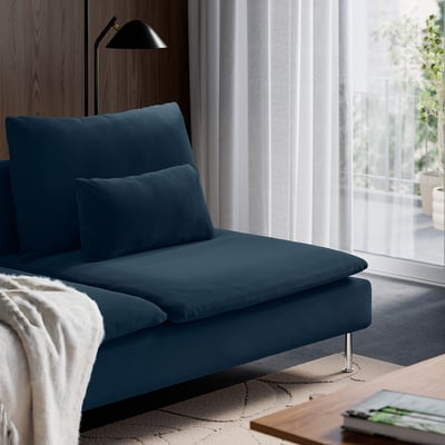 Dark blue sofa near window, modern & cosy.