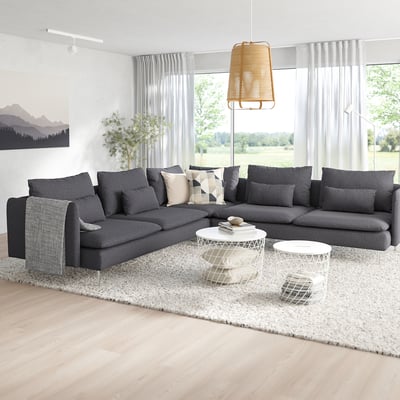 Modern living room with SÖDERHAMN sectional, geometric pillows, white coffee tables, and large window with grey curtains.