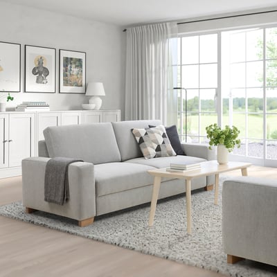 Living room with SÖRVALLEN sofa, table, & garden view.