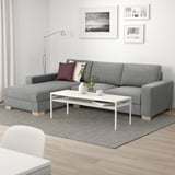 Modern grey SÖRVALLEN sofa, minimalist. Centered with coffee table, rug, and wall art. Upholstered fabric.