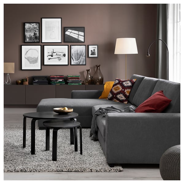 Modern living room featuring a grey SÖRVALLEN sofa with colorful pillows, a black coffee table, and wall art.